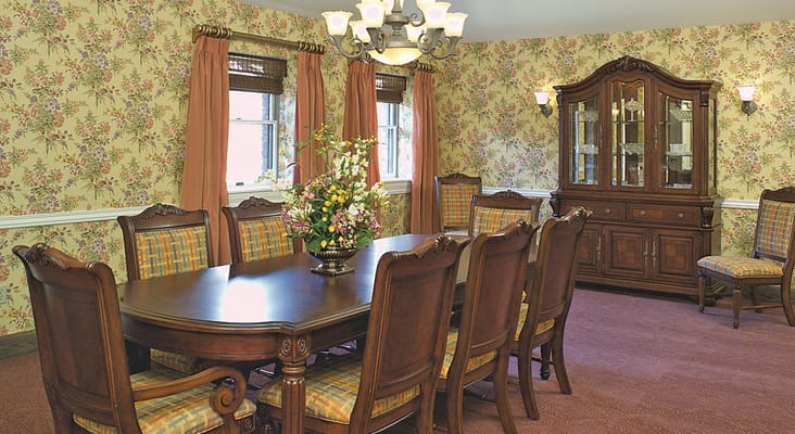Elegant dining room with floral wallpaper and wooden furniture