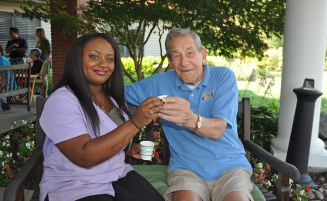 A resident and staff member enjoying a drink outdoors