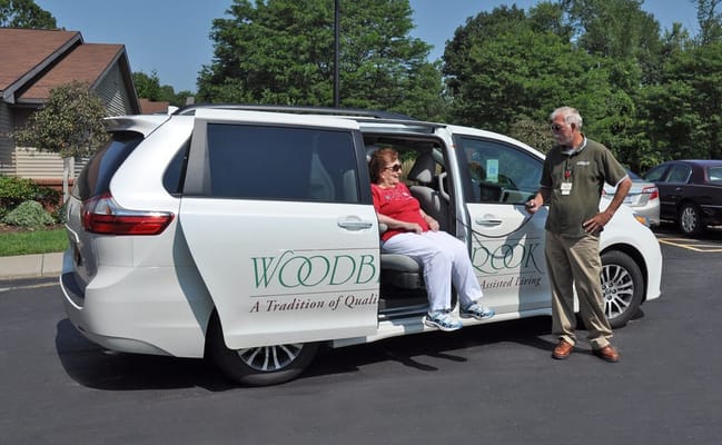 Resident and staff member by the facility shuttle van