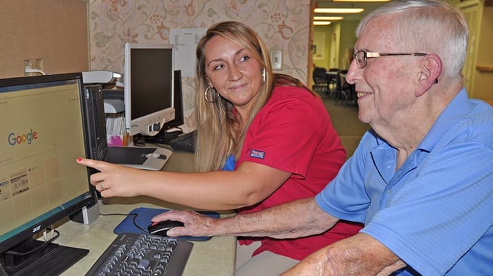Staff assisting a resident with computer use