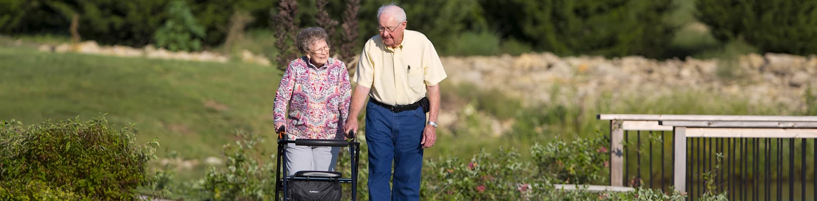 An elderly couple walking in a garden