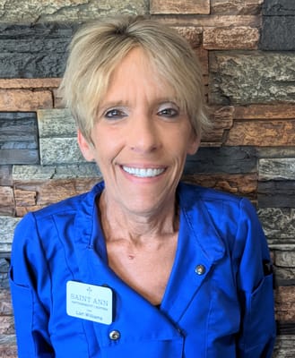 Staff member wearing a name badge at Saint Ann