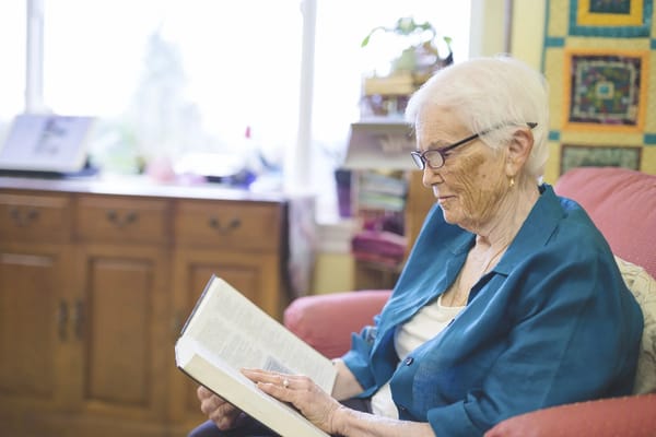 Resident reading a book in a cozy chair