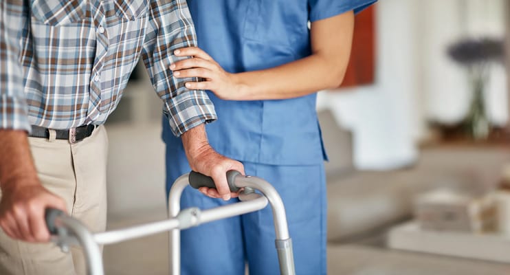 Nurse assisting a resident with a walker