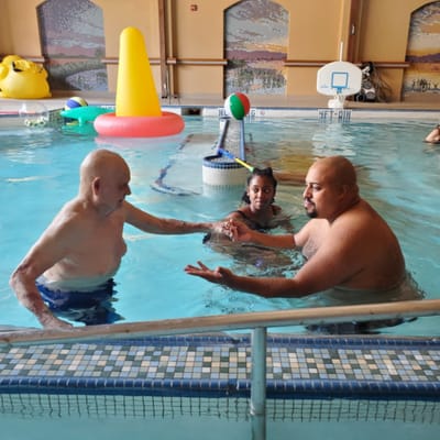 Residents enjoying water activity in a pool