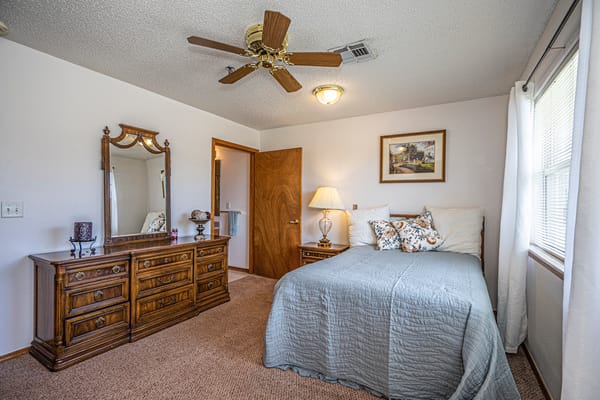 A cozy resident room with a bed and dresser