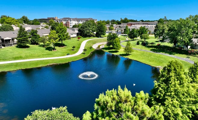 Aerial view of a serene landscape with a pond and walking paths
