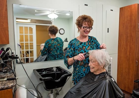 Stylist giving a haircut to a resident in the salon