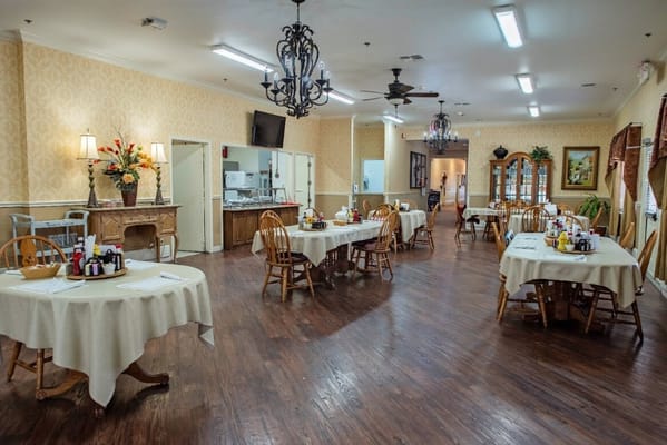 Dining room with neatly set tables and floral decor