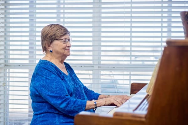 Senior woman playing piano in a bright room