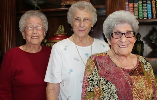 Three smiling residents in a cozy interior setting