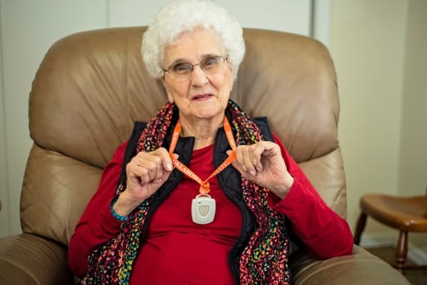 Resident proudly holding a medical alert pendant