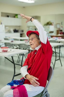 Senior woman raising her hand in an activity room