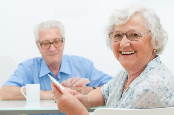 Residents playing cards in a bright activity room