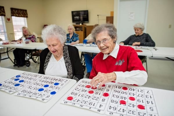 Residents playing bingo in a bright activity room