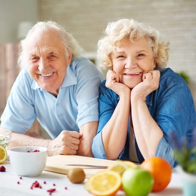 Happy elderly couple preparing food together