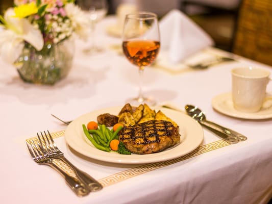 A plated meal with green beans, potatoes, and steak