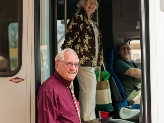 Residents boarding a facility transport vehicle