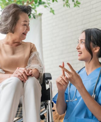 Nurse talking with a smiling resident in a bright room