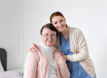 A caregiver and resident smiling together indoors