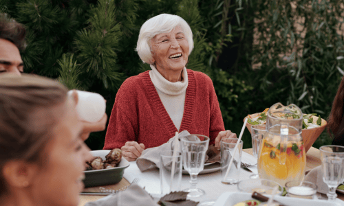 Residents enjoying a meal outdoors with laughter