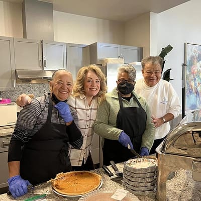 Staff and residents enjoying dessert in the kitchen