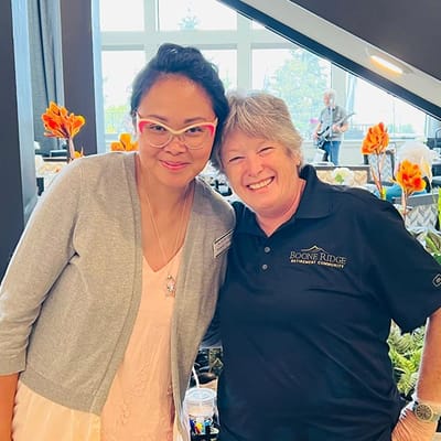 Two staff members smiling together at an event