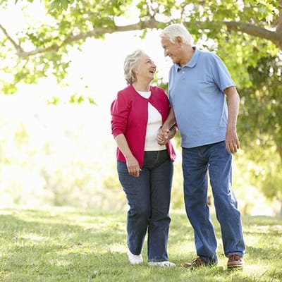 An older couple walking together in a garden