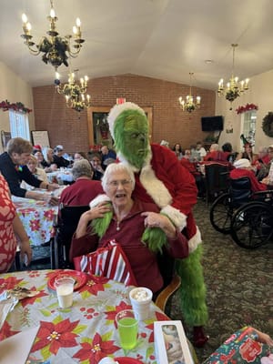 Residents enjoying a festive event with the Grinch character