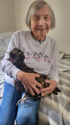 Resident holding a chicken in her lap