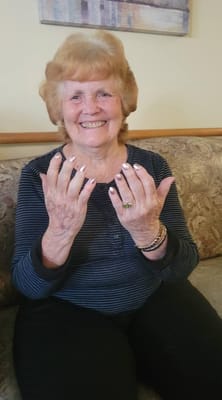 Resident showing off her manicured nails in a cozy setting