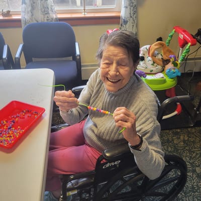 Resident crafting colorful beads in a common area