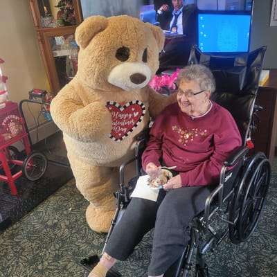 Resident enjoying time with a large teddy bear