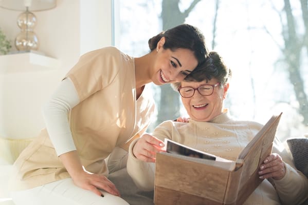 A caregiver and a resident enjoying a photo album together