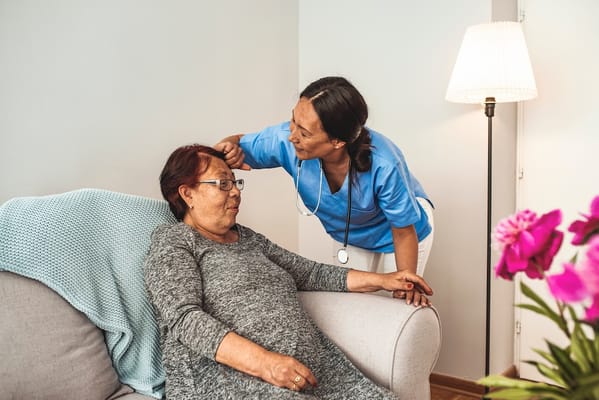 Nurse attending to a resident in a cozy living space