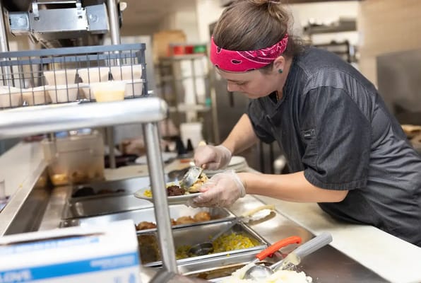 Staff member plating food in the kitchen