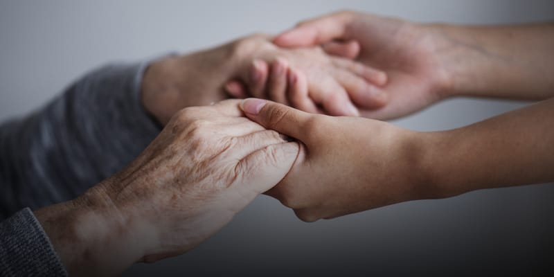 Elderly and young hands clasped together
