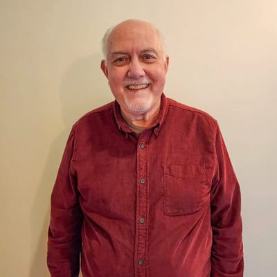 Smiling resident in a maroon shirt against a plain background
