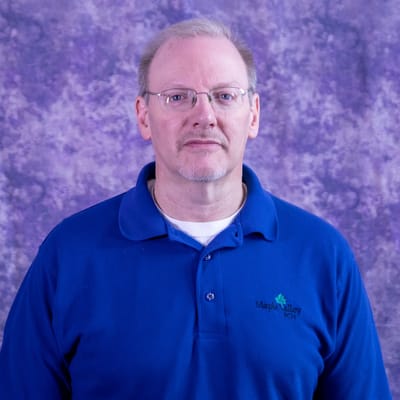 Staff member in a blue polo shirt with the facility logo