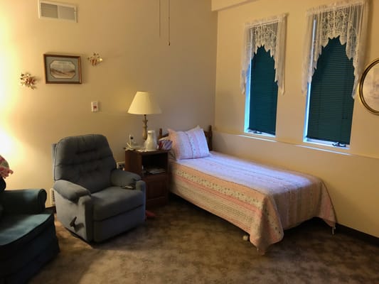 Cozy resident room with bed and chair