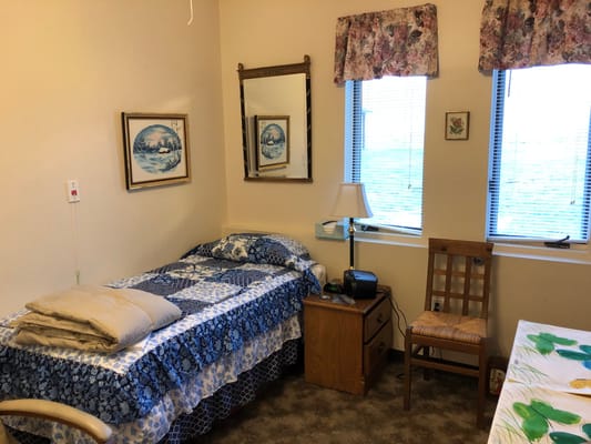 Private resident room with a bed and chair