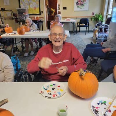 Resident painting a pumpkin in an activity room
