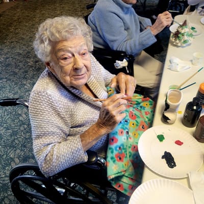 Senior resident painting during an activity session
