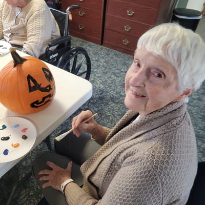 Resident painting a pumpkin during an art activity