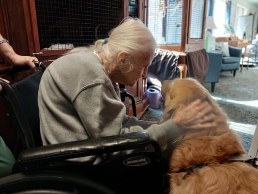 A resident interacting affectionately with a therapy dog
