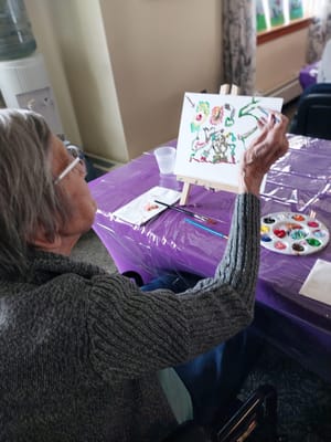 Senior resident painting during an art activity