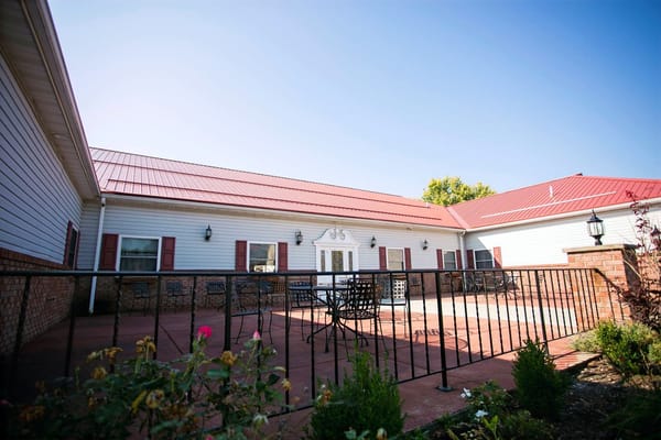 Exterior view of a senior living facility with outdoor seating