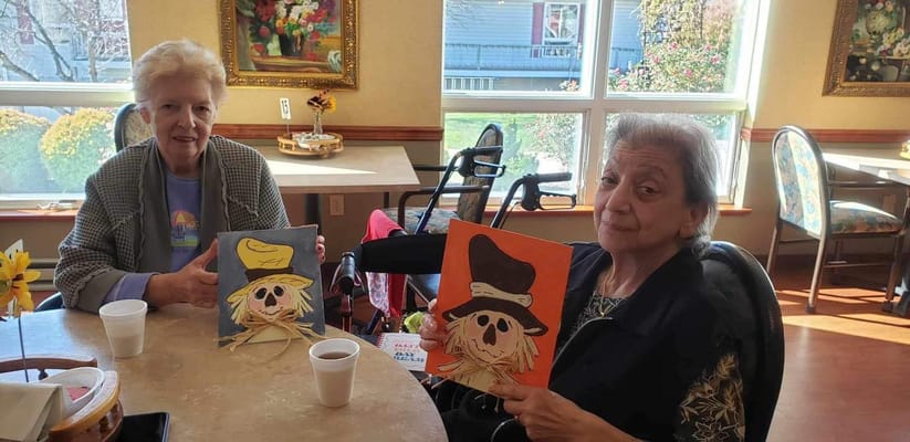 Residents painting in a common area with festive decorations