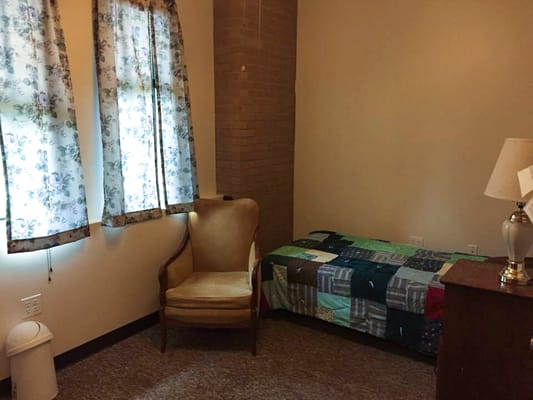 Cozy resident room with bed and chair