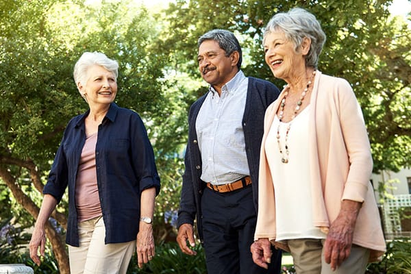Three residents enjoying a walk in the garden